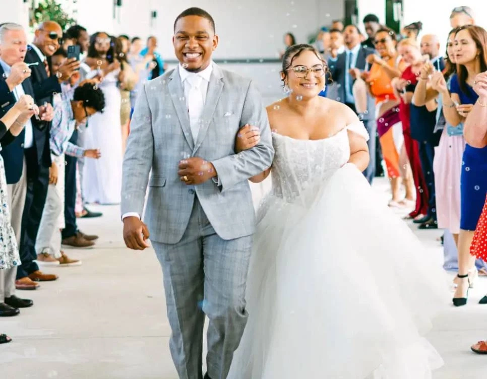 Сouple wearing a white gown and a gray suit